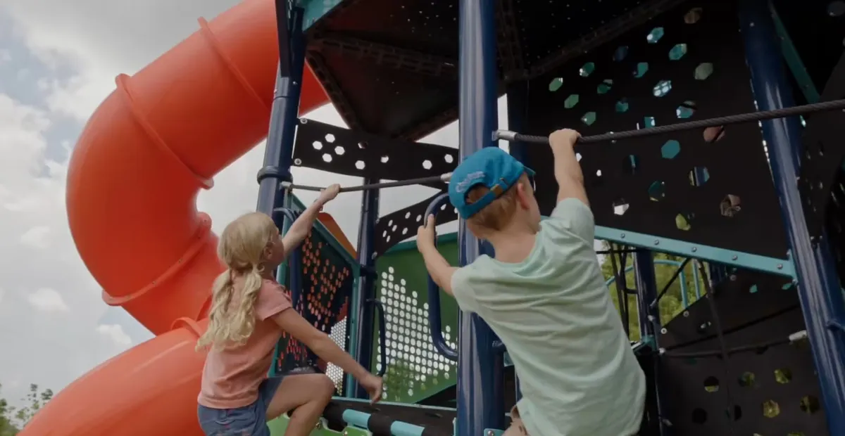Kids climbing a playground rock wall