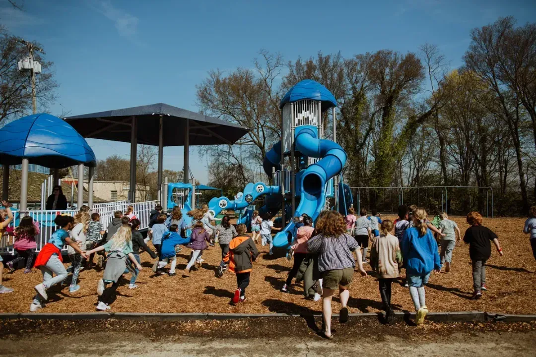 Children running toward a newly installed playground